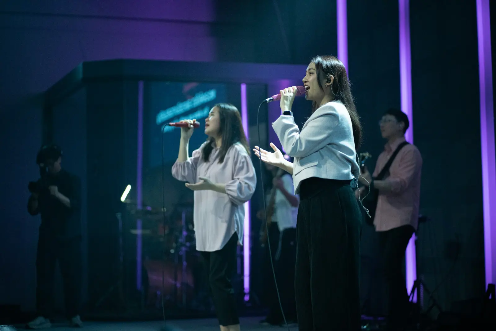 Dos cantantes de un equipo de alabanza en el escenario